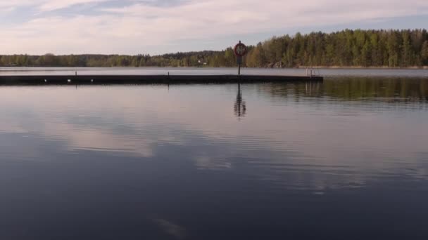 Plan idyllique d'un pont flottant sur un lac par une journée ensoleillée. — Video