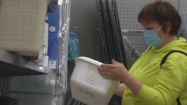 Mağazada maske takan orta yaşlı bir kadının yakın çekimi..