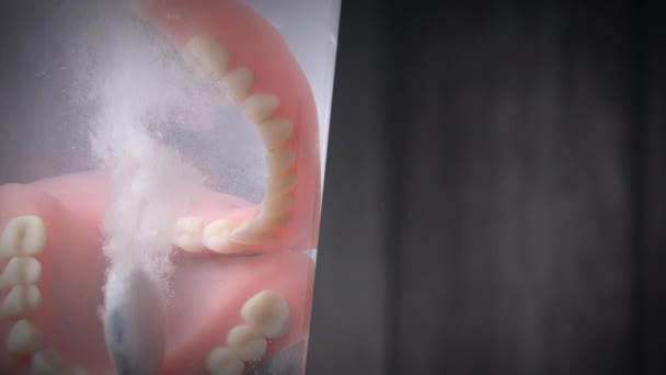 Primer plano de una tableta limpiadora de dientes de prótesis disolviéndose en agua. — Vídeo de stock