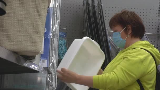 Closer shot of a caucasian lady wearing a mask in a store. — Stockvideo