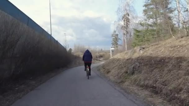 Olgun bir kadın Vantaa Finlandiya 'da dar bir yolda bisiklet sürüyor. — Stok video