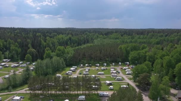 Belo tiro aéreo de um parque de caravanas no meio de uma floresta. — Vídeo de Stock