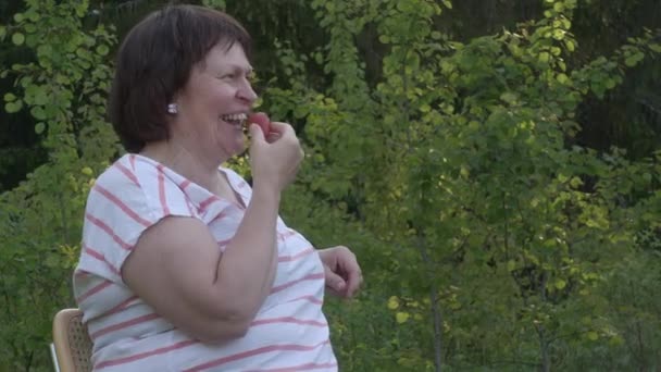 Verbazingwekkend schot van een blanke dame lachen en eten van een aardbei. — Stockvideo