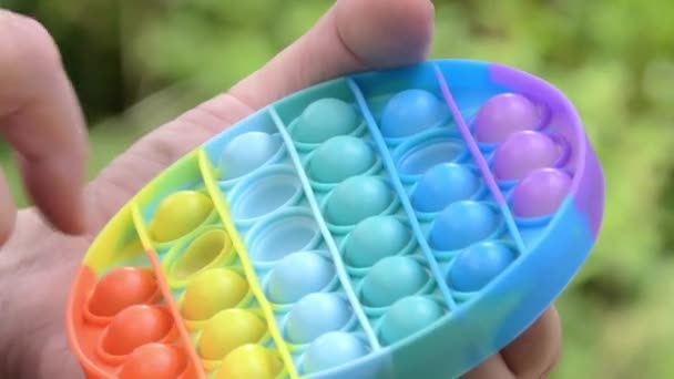 Detailní záběr někoho pomocí barevné pop it toy. — Stock video