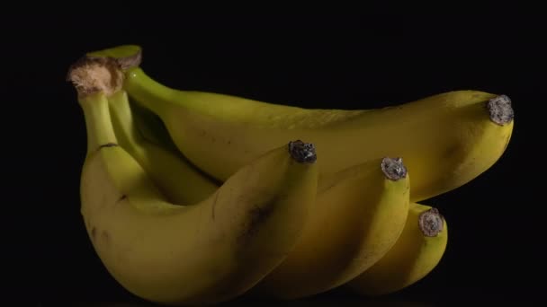 Крупним планом знімок мокрих обертових бананів з чорним тлом . — стокове відео