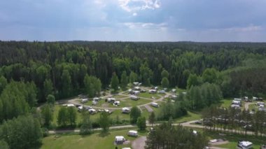 Awesome drone shot of a trailer park surrounded by a forest.