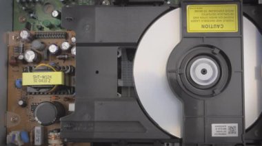 Bir dvd çalarken DVD oynatıcının içini gösteren yakın çekim.