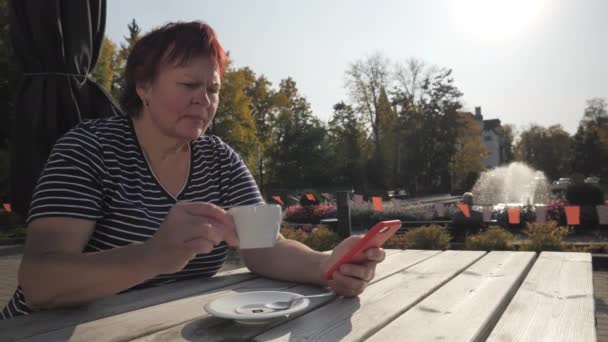 Kobieta w średnim wieku pijąca kawę w mieście Imatra 4k — Wideo stockowe