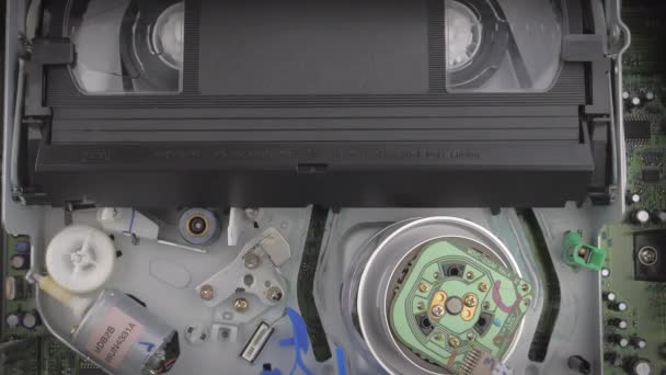 Closeup shot toont de binnenkant van een vcr terwijl een vhs cassette wordt ingebracht. — Stockvideo