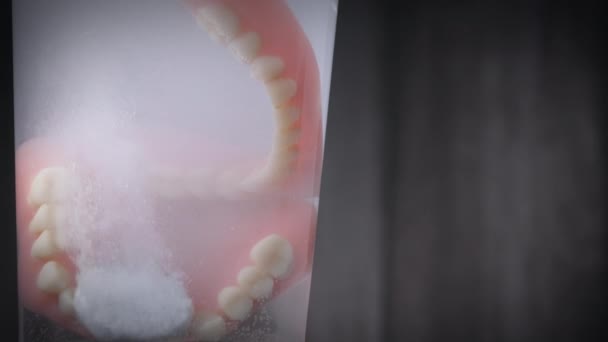 Closeup shot of prosthesis teeth being cleaned by a dissolving tablet. — Stock Video