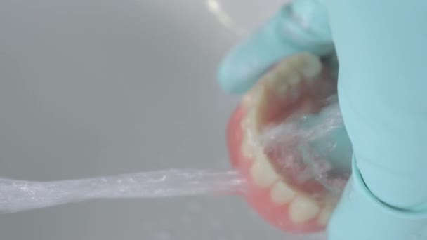 Detailní záběr protézy, jak se myje zuby pod tekoucí vodou. — Stock video