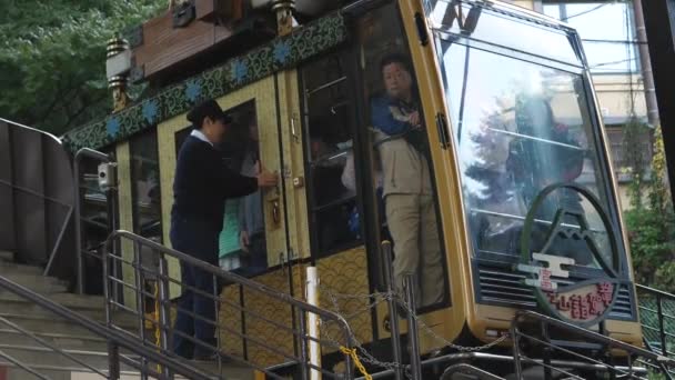 Un accompagnateur ferme la porte du funiculaire dans le parc Kawaguchiko Tenjozan au Japon — Video