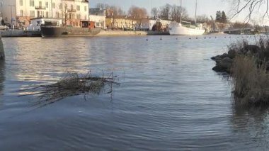 Porvoo.Finland-12 Aralık 2020: Porvoo Finland 'ın arka planında güzel mimari ve doğayı gösteren binalarla nehre daha yakın çekim. Kamera yavaşça yukarı doğru eğiliyor.