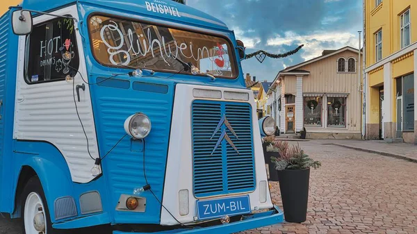 Porvoo, Finlandiya - 08 Aralık 2020: Mavi Citroen yemek kamyonu, tuhaf binalarla çevrili bir kaldırım taşı caddesinde park halinde, canlı ve davetkar bir atmosfer yaratıyor.