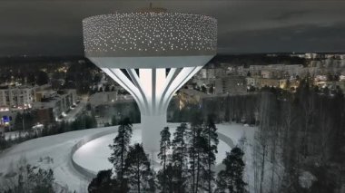 Vanta.Finlandiya-29 Aralık 2021: Hiekkaharju Vantaa 'daki yeni su kulesinin insansız hava aracı görüntüsü. Kış zamanı. Güzel şehir manzarası. Gece vakti. Kamera yavaşça ileri gidiyor.