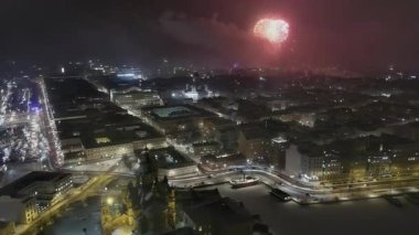 Helsinki. Finlandiya-31 Aralık 2021: Arka planda havai fişeklerle Helsinki 'nin merkezini gösteren insansız hava aracı görüntüleri. Kış zamanı. Güzel şehir manzarası. Yeni yıl arifesi. Kamera yavaşça yana hareket ediyor.