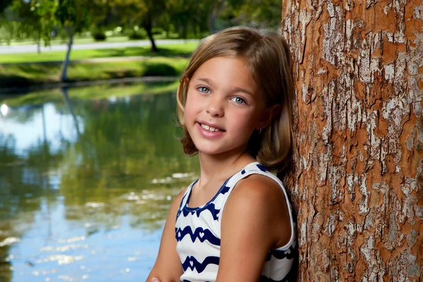 Giovane ragazza si appoggia contro albero — Foto Stock