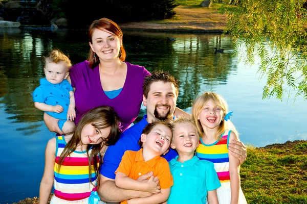 Grande famiglia giovani bambini da un lago — Foto Stock