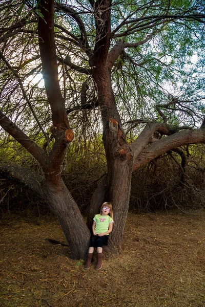 Niña llorando en la base de un árbol — Foto de Stock