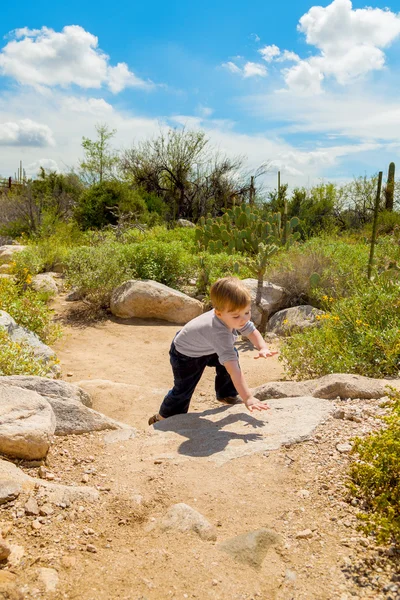 Menino escalando rochas no deserto — Fotografia de Stock