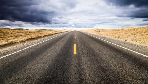 Under the clouds, the road to the distance. — Stock Photo, Image