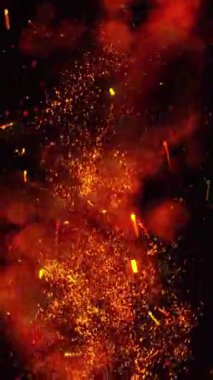 Arka planda duman bulutları ve ateşten yükselen kıvılcımlar var..