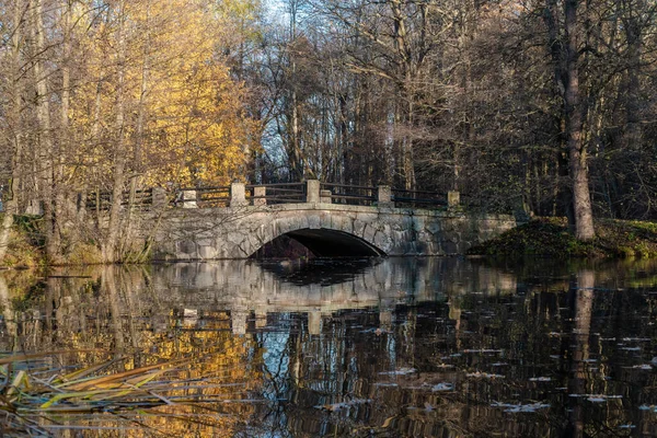 A ponte de pedra pitoresca através do rio Cristatella Park Sergievka perto da cidade Lomonosov. — Fotografia de Stock