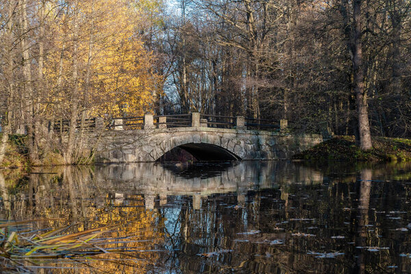 Живописный каменный мост через реку Кристателла Парк Сергиевка возле города Ломоносов.