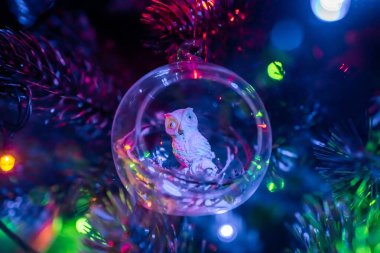 - Rusya. Saint-Petersburg 'da. Noel ağacı süsleme baykuşu, çelenklerin ışığında cam bir topta..
