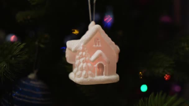 ロシアだ サンクトペテルブルク 色付きのガーランドの光の中で輝くおとぎ話の雪に覆われた家の形でクリスマスツリーの装飾 — ストック動画