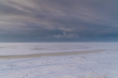 - Rusya. Kronstadt 'ın güney kıyısından Finlandiya' nın donmuş körfezine ve ufukta kara bulutlara bakın..
