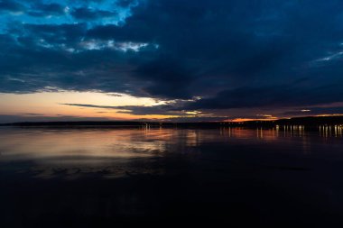 - Rusya. 16 Mayıs 2021. Bulutlu bir gökyüzü, şafaktan önceki Mayıs gecesi Leningrad bölgesindeki Sukhodolsky Gölü 'nde..