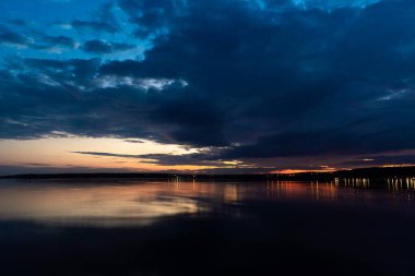 - Rusya. 16 Mayıs 2021. Bulutlu bir gökyüzü, şafaktan önceki Mayıs gecesi Leningrad bölgesindeki Sukhodolsky Gölü 'nde..