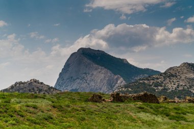 Kırım Cumhuriyeti 'ne. 15 Temmuz 2021. Sudak kentindeki Ceneviz kalesinden Novy Svet köyündeki Sokol Dağı 'nın güneşli havasında resim gibi bir manzara.