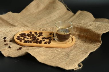 Fırınlanmış fasulyeli sıcak espresso 'nun temiz ve modern bir sunumu. Güçlü görsel etki için siyah üzerine izole.