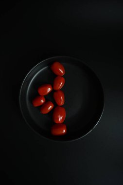 Yüksek kontrastlı düz domatesler bir figür oluşturuyor. Diyet planları, geri sayımlar veya sağlıklı sıralama için basit minimalist tasarım.
