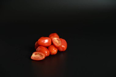 Esmer arka planda taze organik domates grubu. Gıda blogları, menüler ve pazarlama için temiz mutfak imajı.