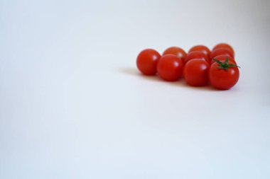 Yumuşak odaklı ve fotokopi alanı olan taze vişneli domateslerin minimalist kompozisyonu hayatın, yaz yürüyüşlerinin, doğanın ve sağlıklı beslenmenin zevkini yansıtıyor..