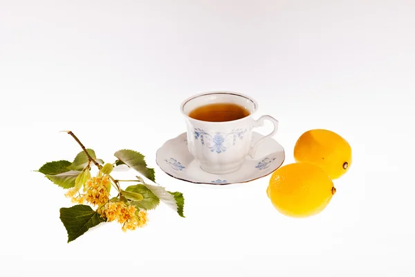 白い背景にレモンとハーブティーのカップ — ストック写真