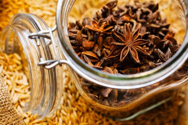İçinde kuru yıldız anisi olan bir torba anis tohumu ve kavanoz. 