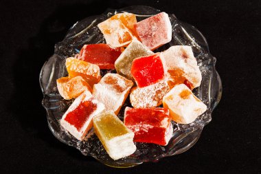 Türkçe zevklerin çeşitliliği, cam kasede servis ediliyor, siyah arka planda izole edilmiş.