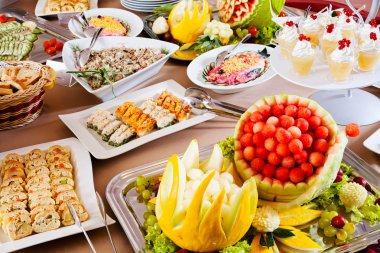 Büfe masasında çeşitli meyve ve salatalar var.