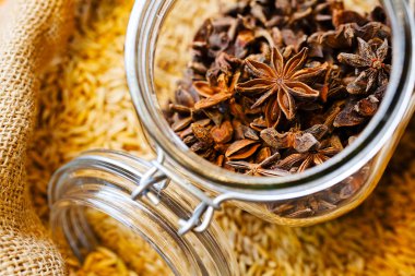 İçinde kuru yıldız anisi olan bir torba anis tohumu ve kavanoz. 