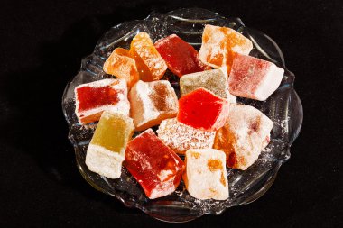 Türkçe zevklerin çeşitliliği, cam kasede servis ediliyor, siyah arka planda izole edilmiş.