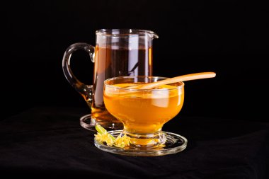 Ihlamur bal Ihlamur çiçek ve küçük sürahi siyah arka plan üzerine izole bal, tam ile fincan