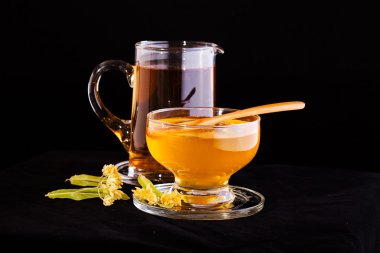 Ihlamur bal Ihlamur çiçek ve küçük sürahi siyah arka plan üzerine izole bal, tam ile fincan