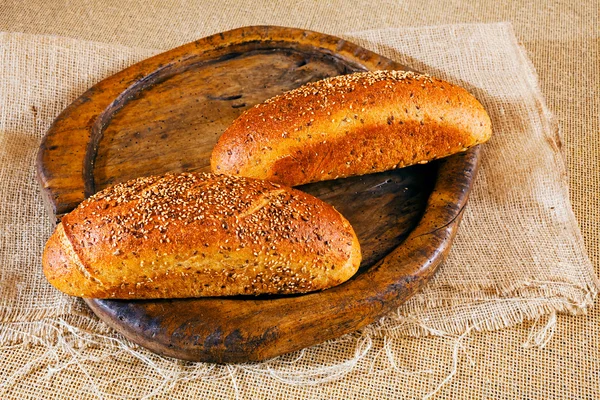 Due Baguette Marroni Condite Con Semi Diversi Tavola Rotonda Legno — Foto Stock