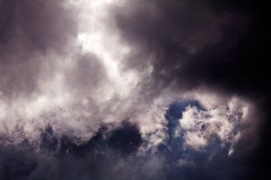 Siyah gökyüzü, gri ve siyah fırtınalı bulutlar ve gün ışığı geliyor.