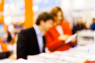 Man and woman sitting at the table talking; blurred 100%