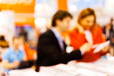 Man and woman sitting at the table watching tablet; blurred 100%